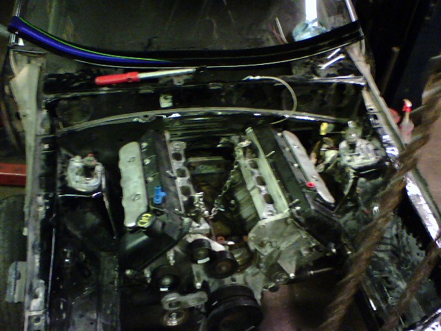 Engine bay of a car with the engine removed, showing the firewall and inner fenders