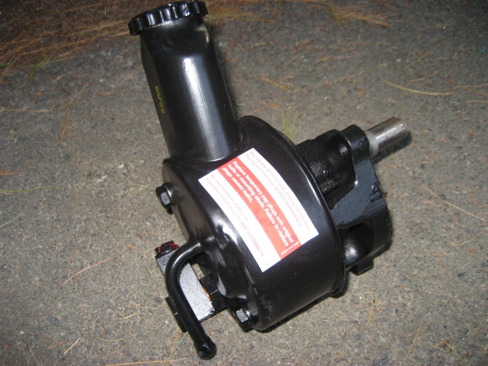 Black steering pump with red and white warning label
