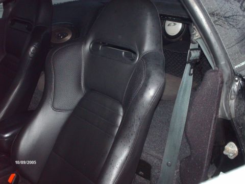 1995 Ford Probe - The interior of a car features custom racing seats and aftermarket speakers visible behind them.