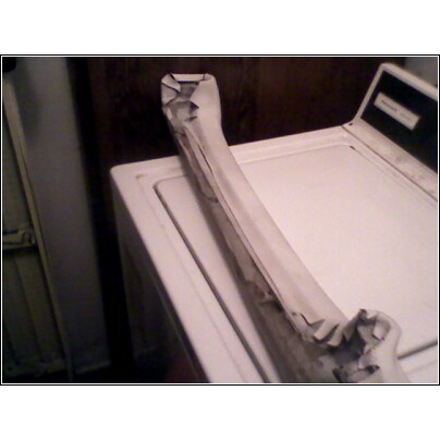 Taped car part on top of a washing machine