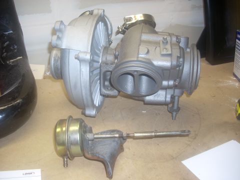 1991 Ford Mustang - Turbocharger and wastegate assembly shown on a workbench surface.