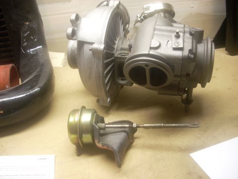 1991 Ford Mustang - A turbocharger and its associated wastegate actuator are displayed on a flat surface.