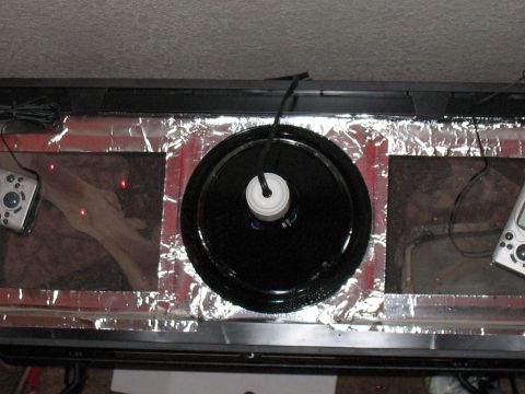 2001 Pontiac Trans Am - This scene depicts a modified aquarium setup a turntable, remote controls, and reflective foil lining, not a 2001 Pontiac Trans Am.