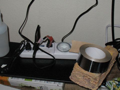 2001 Pontiac Trans Am - An electrical outlet strip is connected to multiple plugs and a timer, with a roll of tape nearby.