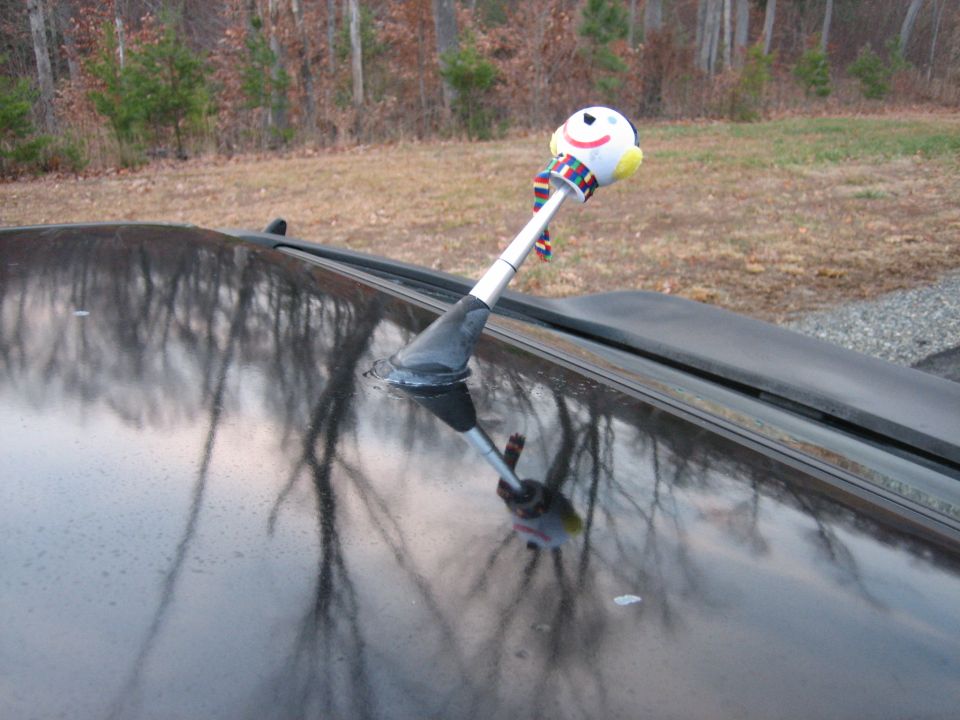 Black car roof with snowman antenna topper