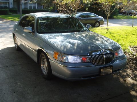 1998 Lincoln Town Car - A light blue Lincoln Town Car is parked on a driveway with a second car visible in the background.