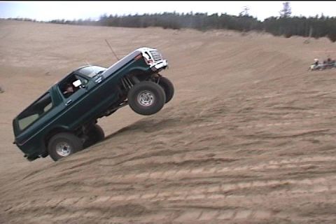 1979 Ford Bronco - Ford Bronco tackling a sand dune with its front wheels airborne.