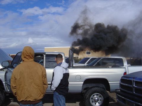 1996 Ford F-250 - Truck is blowing a lot of black smoke. The hood is up on the silver truck.