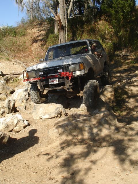 1989 Ford Bronco - This SUV is navigating a rocky trail, with its front end angled towards the viewer.