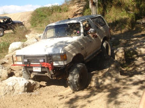 1989 Ford Bronco - This 1989 Ford Bronco is shown tackling a challenging rocky trail, equipped with a Hi-Lift jack on its front bumper.