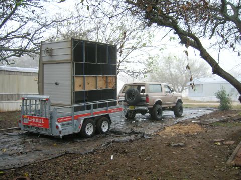 1996 Ford Bronco - 1996 Ford Bronco towing a U-Haul trailer on a muddy lot.
