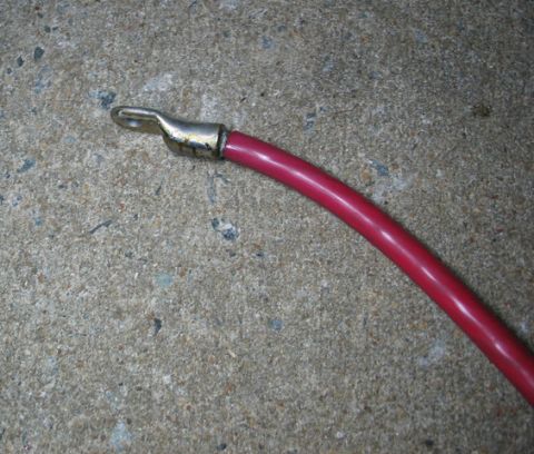 1995 Ford C-350 (Centurion Conversions) - Close-up of a red battery cable with a metal ring terminal connector.