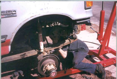 1991 Ford F-250 - Mechanic working on the front suspension of a 1991 Ford F-250 truck.
