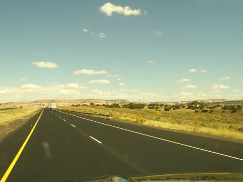 1995 Ford C-350 (Centurion Conversions) - Driving on a highway through a vast desert landscape under a partly cloudy sky.