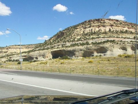 1995 Ford C-350 (Centurion Conversions) - View from inside a vehicle traveling on a highway towards a large mountain with caves.