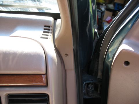 1995 Ford C-350 (Centurion Conversions) - Close-up of the interior A-pillar and dashboard trim, with a vent and wood accent visible.