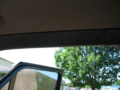 1995 Ford C-350 (Centurion Conversions) - Close-up of an interior trim piece, possibly an A-pillar molding, with visible mounting holes.