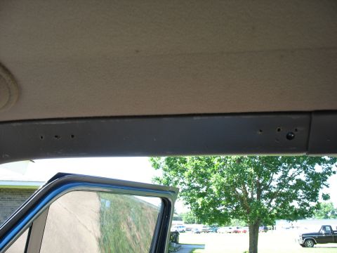 1995 Ford C-350 (Centurion Conversions) - View from inside a vehicle, showing the door frame and headliner with a glimpse of the outdoors and other vehicles.