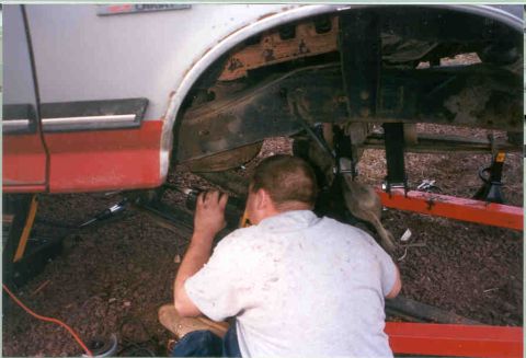 1991 Ford F-250 - Man working on the rear suspension of a 1991 Ford F-250.