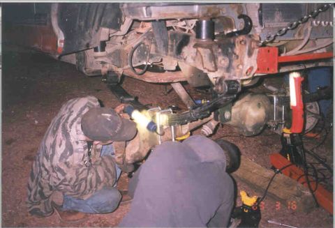 1991 Ford F-250 - Mechanics are shown performing work on the suspension components of a vehicle.