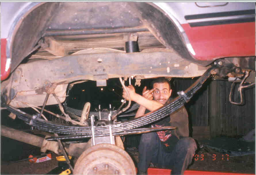 1991 Ford F-250 rear leaf springs and frame with a man underneath