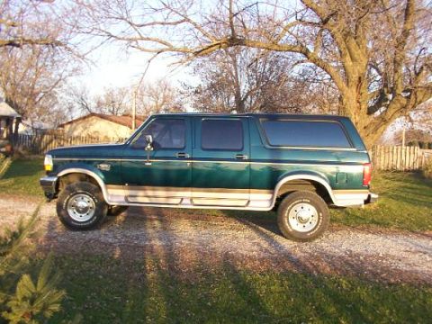 1995 Ford C-350 (Centurion Conversions) - A green Ford Bronco Centurion Conversion is seen from the side on a sunny day.