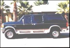 1995 Ford C-350 (Centurion Conversions) - Side profile of a dark blue and silver Ford C-350 Centurion Conversion Van with tinted windows and chrome wheels.