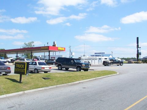 1995 Ford C-350 (Centurion Conversions) - Several vehicles are parked at a Pilot Travel Center on a sunny day.