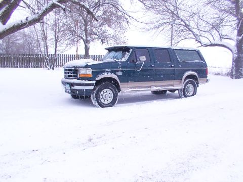 1995 Ford C-350 (Centurion Conversions) - Green Ford C-350 SUV with tan trim sits in a snowy yard during winter.