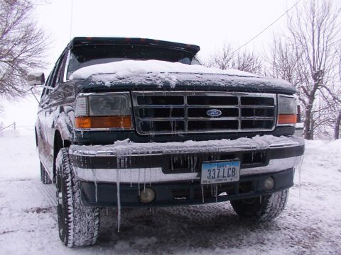 1995 Ford C-350 (Centurion Conversions) - Frontal view of a snow-covered Ford truck with icicles hanging from the bumper and grille.