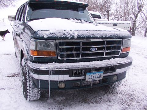 1995 Ford C-350 (Centurion Conversions) - A 1995 Ford F-Series truck is covered in snow and icicles, with another 4x4 truck visible in the background.