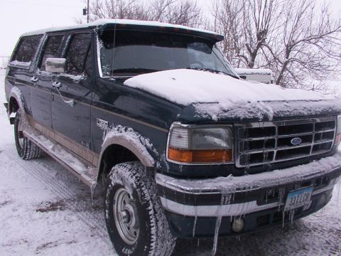 1995 Ford C-350 (Centurion Conversions) - A Ford SUV sits covered in snow and ice on a winter day.