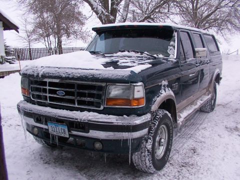 1995 Ford C-350 (Centurion Conversions) - SUV with snow on its hood and windshield, parked in a snowy environment with icicles hanging from the bumper.