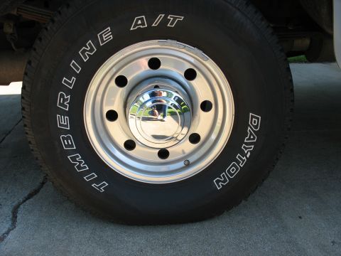 1995 Ford C-350 (Centurion Conversions) - Dayton Timberline A/T tire on a chrome wheel with a chrome hubcap.