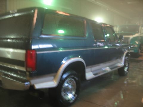 1995 Ford C-350 (Centurion Conversions) - This 1995 Ford C-350 Centurion Conversions SUV is seen in a garage with another vehicle in the background.