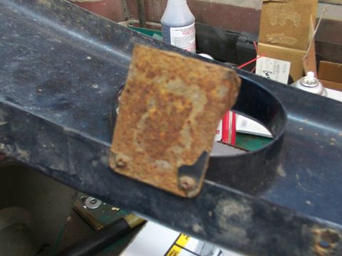 1995 Ford C-350 (Centurion Conversions) - A close-up view of a corroded metal bracket affixed to a dark plastic component.