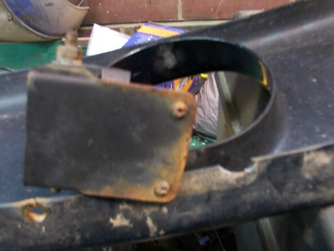 1995 Ford C-350 (Centurion Conversions) - A close-up view of a rusted black bracket attached to a dark blue automotive component.