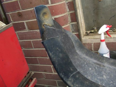 1995 Ford C-350 (Centurion Conversions) - A close-up view of a damaged plastic vehicle bumper section, showing wear and tear.