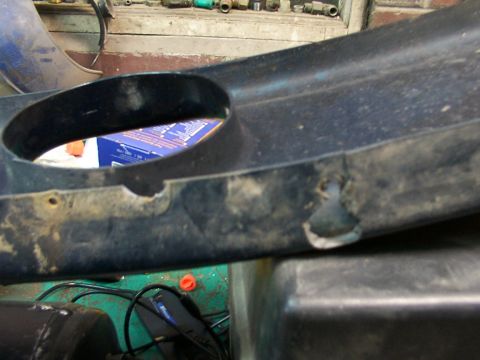 1995 Ford C-350 (Centurion Conversions) - This is a close-up of a damaged plastic vehicle part, likely a front valance.