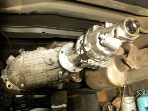 1995 Ford C-350 (Centurion Conversions) - Underside view of a vehicle's transfer case and exhaust system, showing mechanical components.