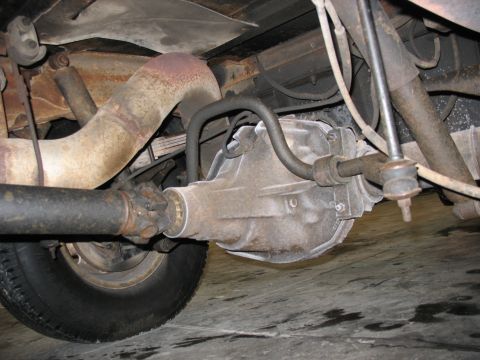 1995 Ford C-350 (Centurion Conversions) - Close-up of a vehicle's rear axle assembly and exhaust system components.