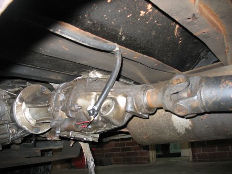 1995 Ford C-350 (Centurion Conversions) - Close-up view of the vehicle's drivetrain, including the transmission and driveshaft, with visible signs of wear and tear.