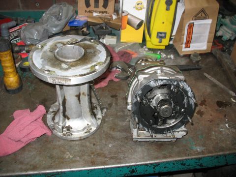 1995 Ford C-350 (Centurion Conversions) - Disassembled transmission parts are laid out on a workbench, with tools and shop supplies visible in the background.
