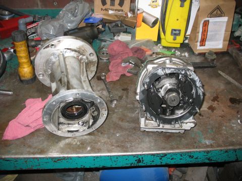 1995 Ford C-350 (Centurion Conversions) - Disassembled transmission parts sit on a cluttered workbench, awaiting repair or reassembly.