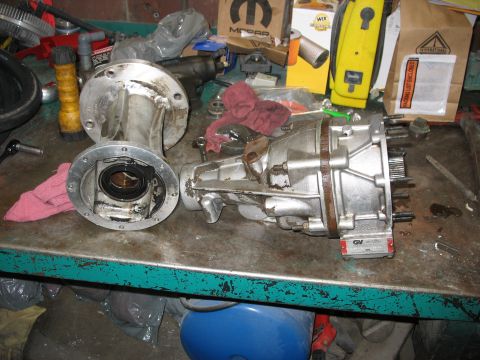 1995 Ford C-350 (Centurion Conversions) - Workbench with disassembled transmission part and various automotive supplies in the background.
