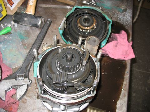 1995 Ford C-350 (Centurion Conversions) - Disassembled transmission or gearbox part with tools on a workbench.