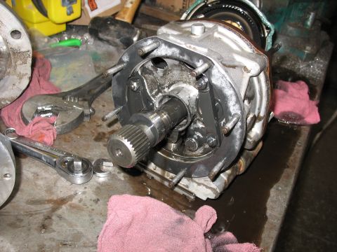 1995 Ford C-350 (Centurion Conversions) - A vehicle transmission part is disassembled on a workbench, surrounded by tools and shop rags.