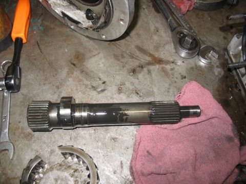 1995 Ford C-350 (Centurion Conversions) - A splined shaft, likely from a transmission or transfer case, rests on a pink cloth with various tools scattered around.