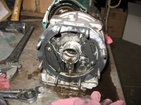 1995 Ford C-350 (Centurion Conversions) - A disassembled differential housing sits on a workbench, surrounded by tools and rags, showing internal brake components.