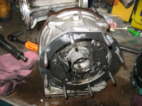 1995 Ford C-350 (Centurion Conversions) - A greasy, disassembled transmission part sits on a workbench, surrounded by tools and shop rags.